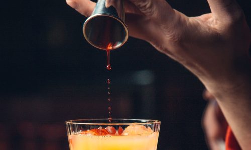 adicionando-xarope-vermelho-no-cocktail-de-laranja
